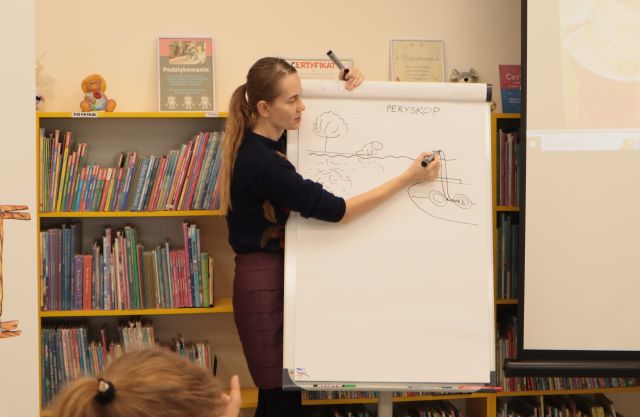 ilustratorka rysuje na flipcharcie