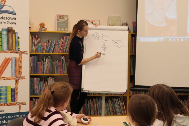 ilustratorka rysuje na flipcharcie