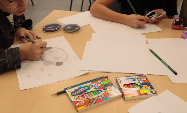 dłonie rysujące na kartkach