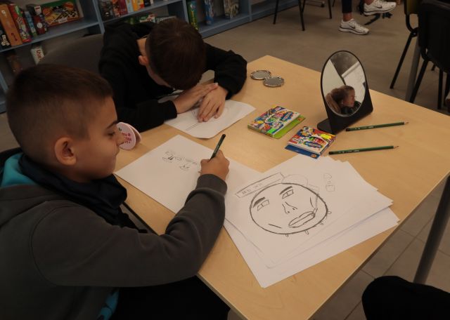 dłonie rysujące na kartkach