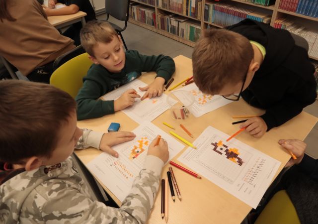 4 chłopców rysuje na kartkach