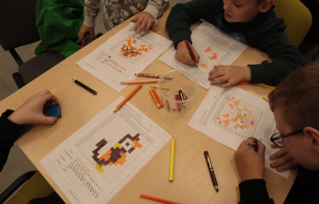 dłonie rysujące na kartkach