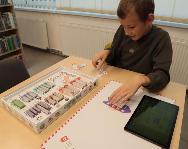 chłopiec układa karty gry Scotie Go