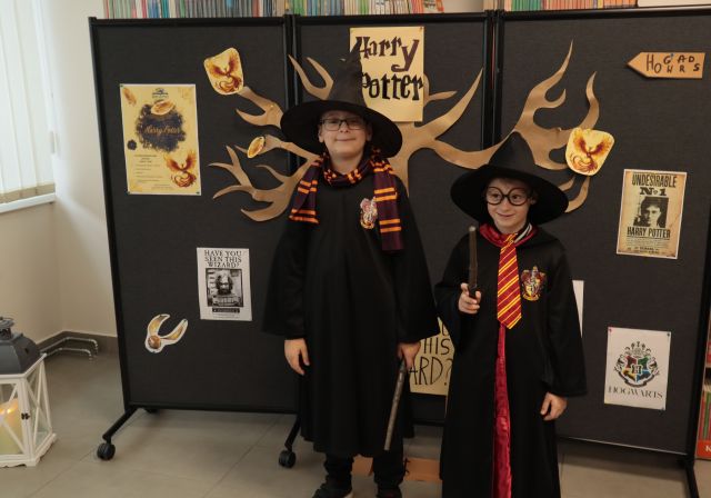 dwóch chłopców pozuje do zdjęcia w strojach Harry'ego Pottera