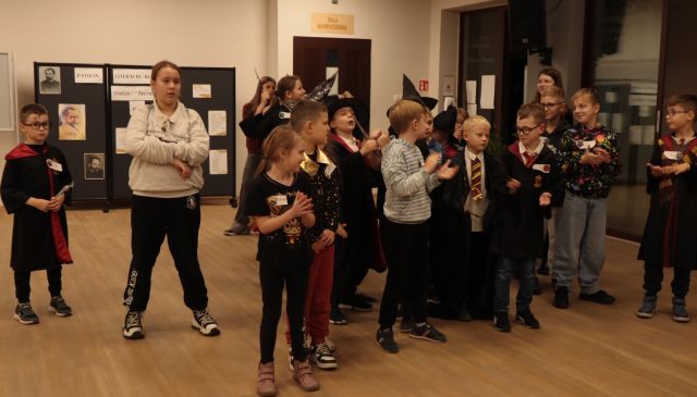 uczestnicy zabawy stoją w holu biblioteki