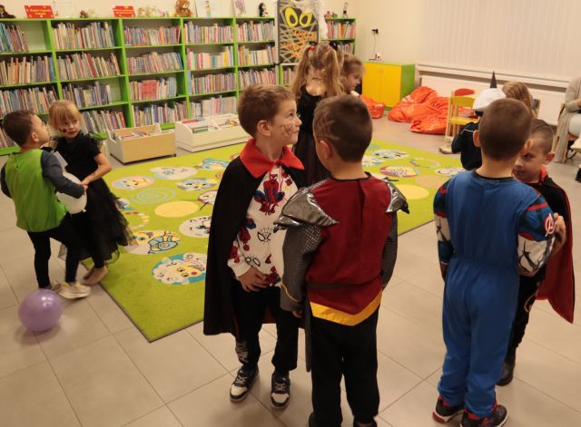dzieci stoją w parach, w tle regały z książkami