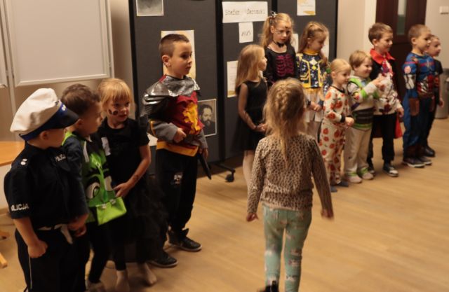dzieci stoją w rzędzie w holu biblioteki