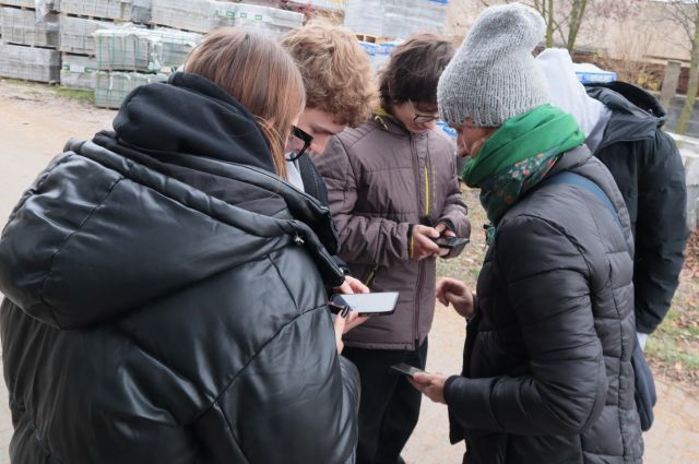 młodzie spaceruje po mieście i notuje w komórkach