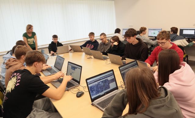 młodzież pracuje przy komputerach i laptopach