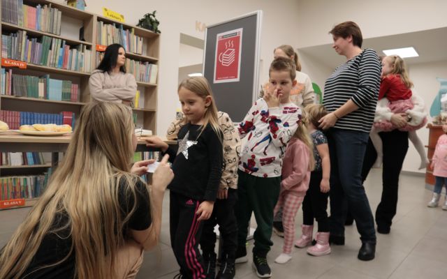 dzieci stoją w kolejce do bibliotekarki z wróżbą