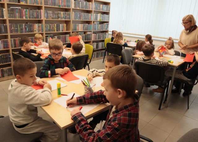 dzieci przy stolikach rysują na kartkach