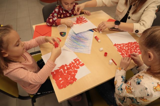 dzieci wyklejają czerwonym papierem Polskę
