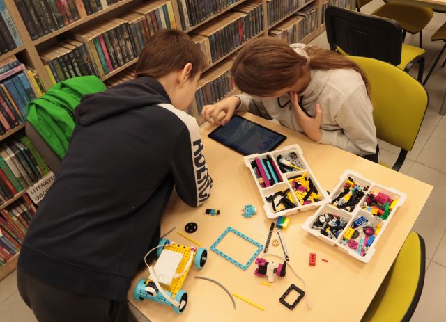 chłopcy budują robota z klocków Lego