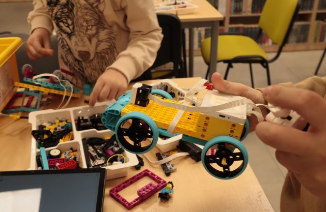 chłopcy budują robota z klocków Lego