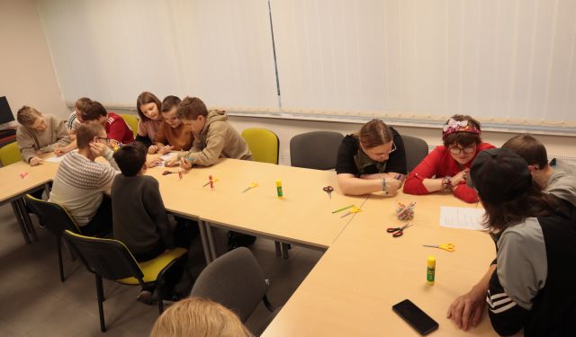 młodzież w sali komputerowej siedzi przy stołach i rozwiązuje test
