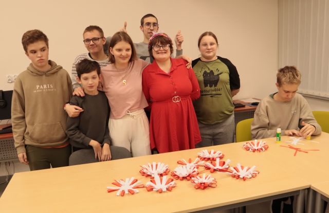 młodzież pozuje do zdjęcia, na stole leżą kotyliony