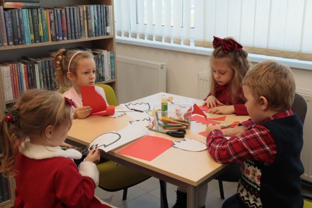 przedszkolaki naklejaja wycięte z papieru tulipany na kartki