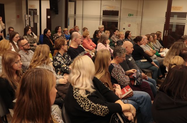 na zdjęciu siedzący na krzesłach uczestnicy spotkania