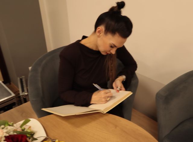 autorka podpisuje się w książce