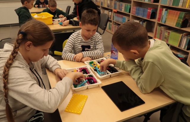 dzieci przy stolikach układają klocki Lego Spike Prome