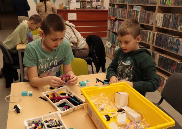 dzieci przy stolikach układają klocki Lego Spike