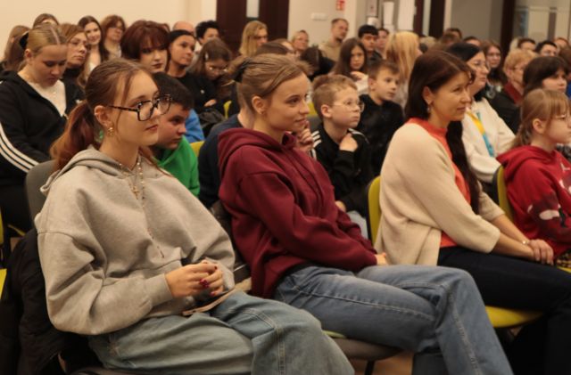 na zdjęciu publiczność siedząca na krzesłach