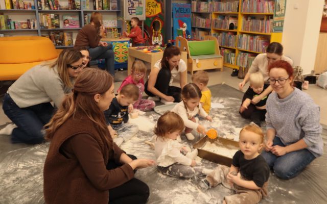 małe dzieci z mamami przesiewają mąkę
