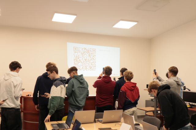 młodzież sczytuje kody QR ze ściany