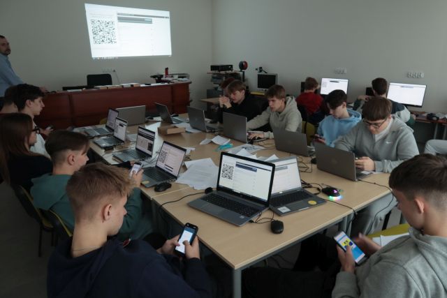 młodzież pracuje na laptopach i smartfonach