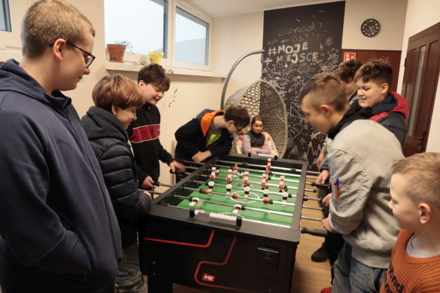 młodzież przy stole z grą w piłkarzyki