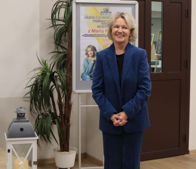 na zdjęciu uśmiechnięta Maria Pakulnis, w tle plakat promujący spotkanie
