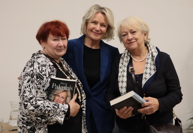 dwie kobiety z książkami pozują do zdjęcia z aktorką Marią Pakulnis