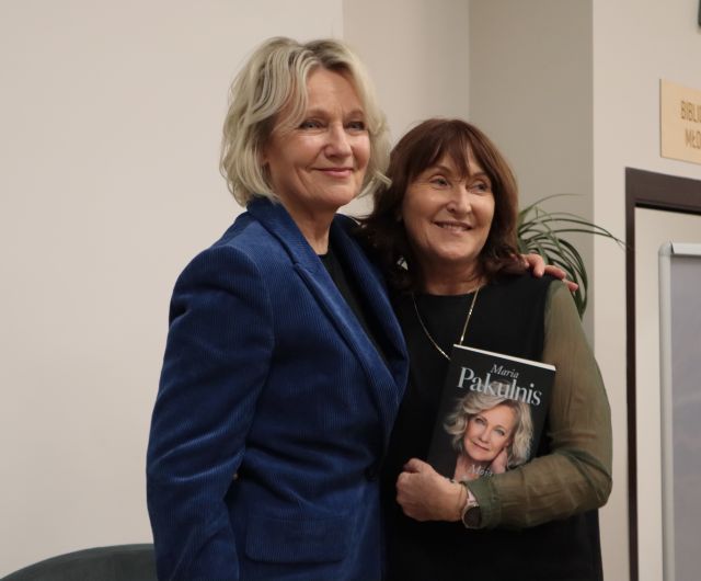 kobieta z książką pozuje do zdjęcia z Marią Pakulnis