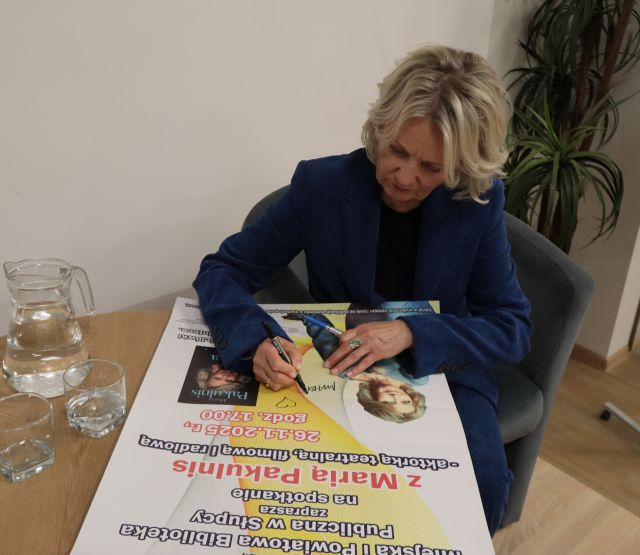 aktorka Maria Pakulnis podpisuje się na plakacie promującym spotkanie z nią