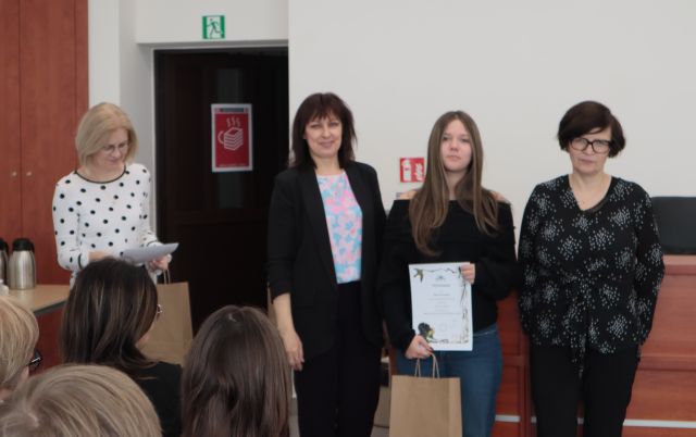 laureatka konkursu z dyplomem i nagrodą pozuje do zdjęcie z bibliotekarką, dyrektorką biblioteki i nauczycielką