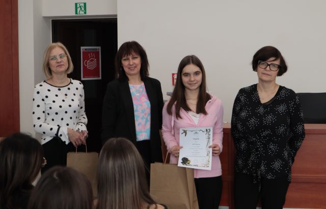 laureatka konkursu z dyplomem i nagrodą pozuje do zdjęcie z bibliotekarką, dyrektorką biblioteki i nauczycielką