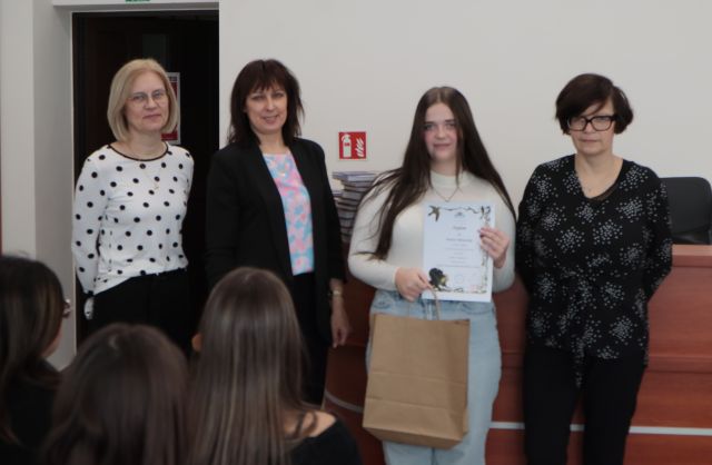 laureatka konkursu z dyplomem i nagrodą pozuje do zdjęcie z bibliotekarką, dyrektorką biblioteki i nauczycielką