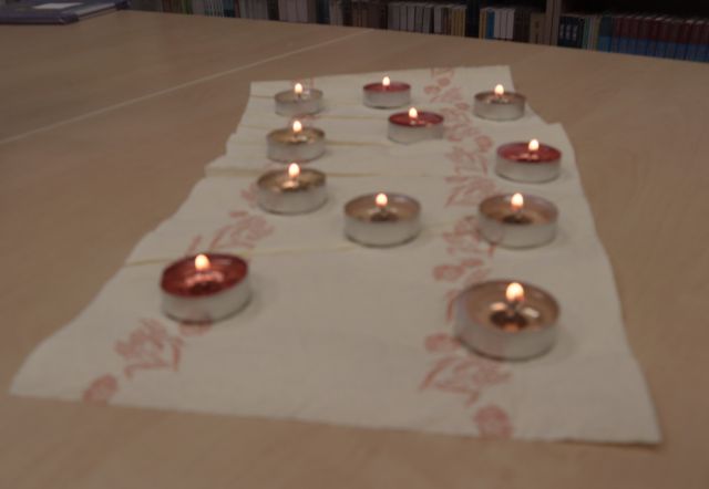 na stole 11 zapalonych małych podgrzewaczy