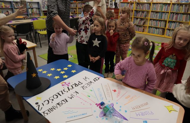 dzieci stoją przed grafiką andrzejkową