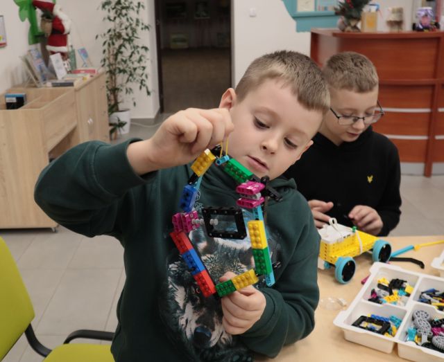 chłopiec prezentuje budowlę z klocków Lego