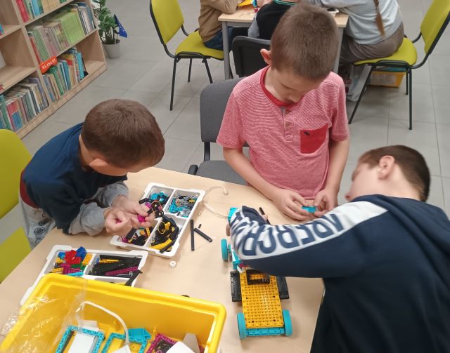 3 chłopców buduje z klocków Lego