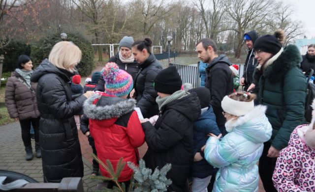 dzieci z rodzicami pobierają następne zadanie w grze terenowej