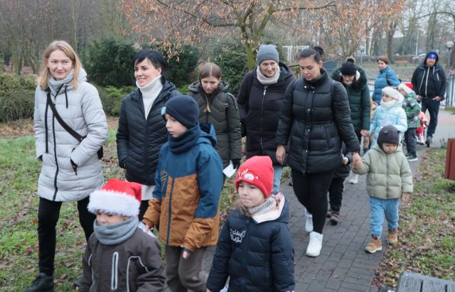 dzieci z rodzicami idą chodnikiem