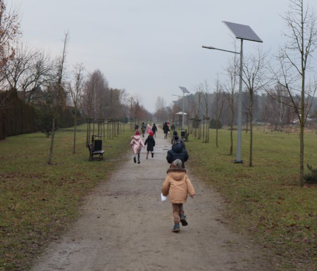 dzieci z rodzicami idą i biegną ścieżką