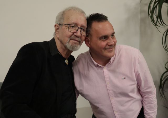 Na zdjęciu znajduję się Krzysztof Daukszewicz oraz stojący obok niego mężczyzna w różowej koszuli.