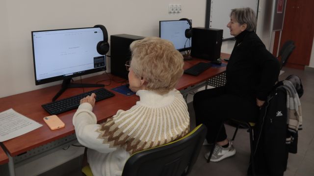 Na zdjęciu znajdują się dwie kobiety przy komputerach.