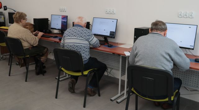 Na zdjęciu znajduję się dwóch mężczyzn oraz jedna kobieta, każdy siedzi przy swoim komputerze i szukają informacji.