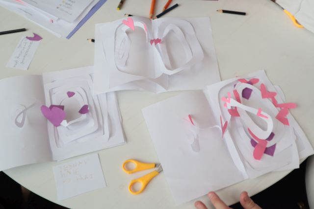 Na zdjęciu znajdują się laurki z efektem 3D, które są położone na stole.