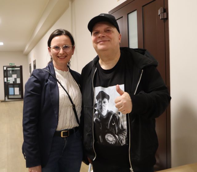 Na zdjęciu znajduje się kobieta stojąca do zdjęcia z Krzysztofem Skibą, który pokazuje kciuk w górę.