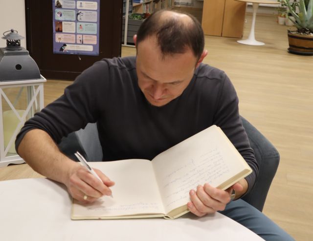 Na zdjęciu znajduje się Konrad Wojciechowski wpisujący się do Kroniki.